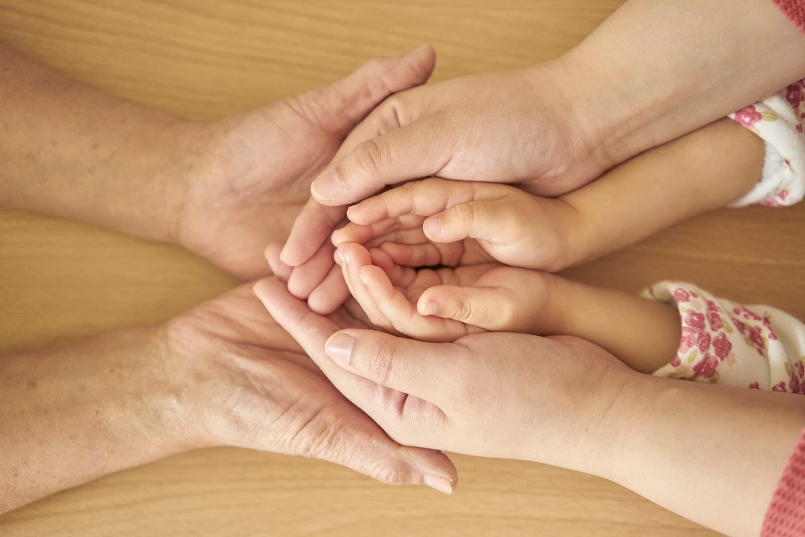Four hands of different ages stacked